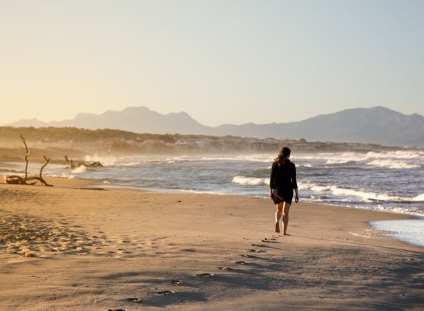 Young woman walking on shore near water