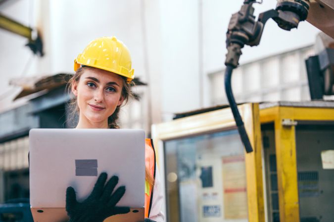 Female industrial engineer or technician worker in hard helmet with laptop