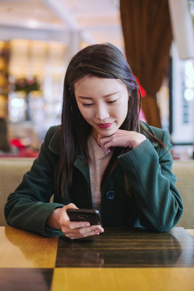 Asian woman using smartphone in cafe