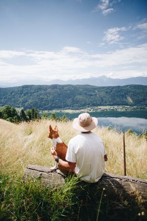 Back of man and dog overlooking scenic view, portrait