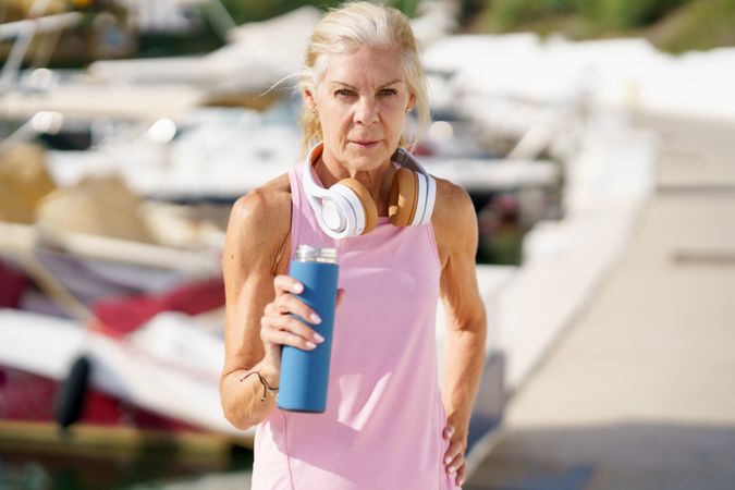 Mature female with grey hair drinking between exercise