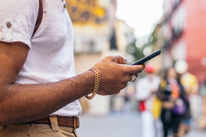 Unrecognizable Black man using smartphone outdoors in the city