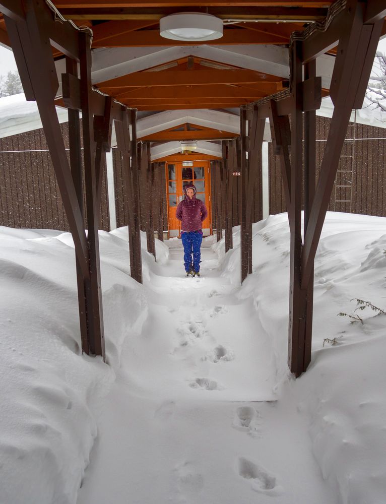 Woman standing in wintry entrance to lodge