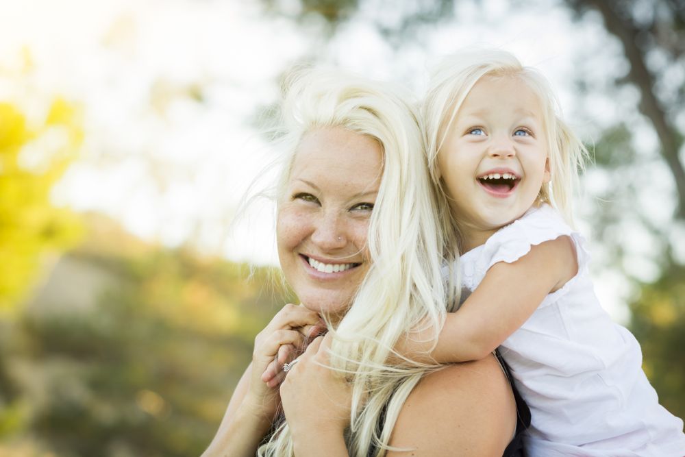 Mother and Little Girl Having Fun Together in Grass