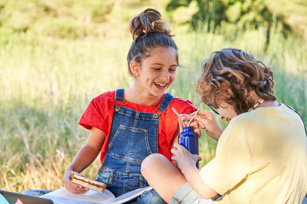 Laughing children having picnic in park