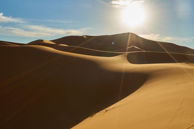 Sand dunes and blue sky with sun