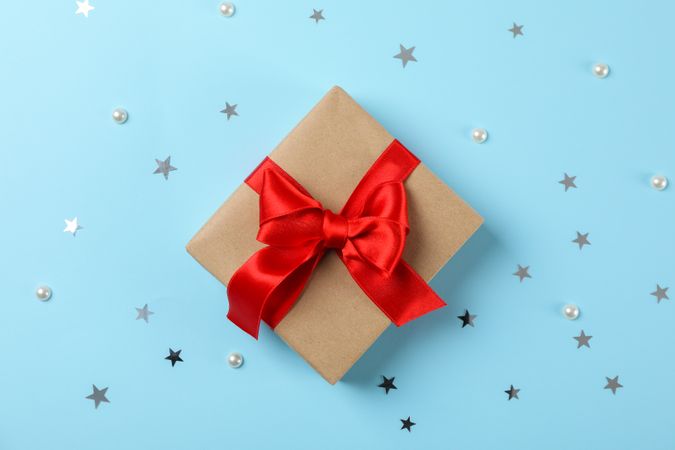Gift box with bow on blue background, space for text