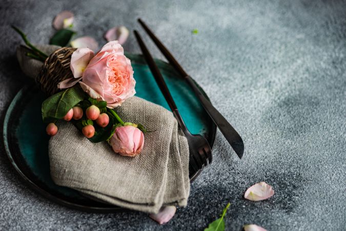 Delicate pink flowers on grey napkin and teal plate