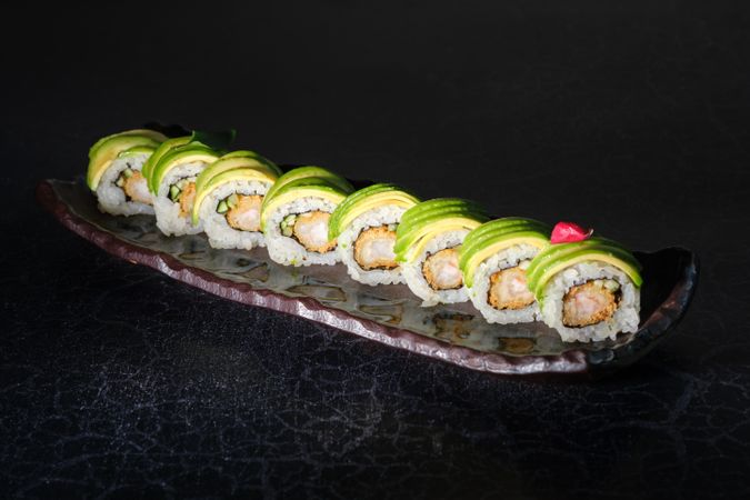 Delicious sushi rolls on marble plate in restaurant
