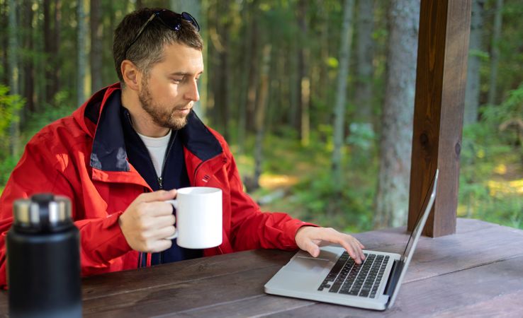 Man working remotely in forest gazebo