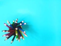 Multicolor pencils light blue background shot from top angle