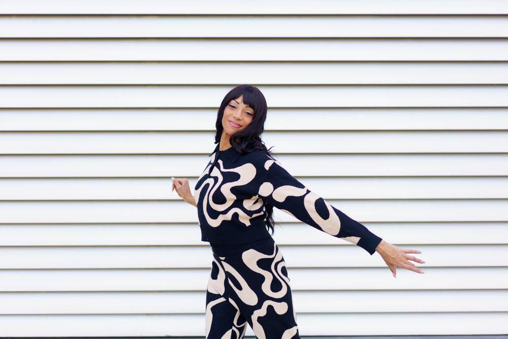 Woman dancing in front of lined wall