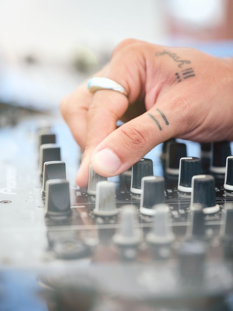 Unrecognizable DJ adjusting sound of disco music