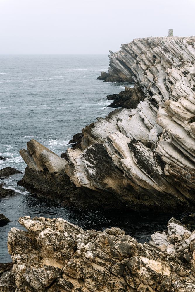 Rocky formations in the island of Baleal on the Atlantic coast in a foggy day. Peniche, Portugal