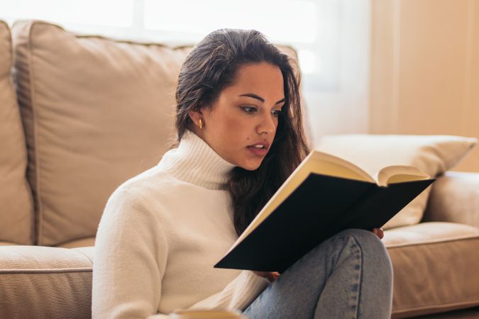 Relaxing at Home: Young Woman Reading a Book