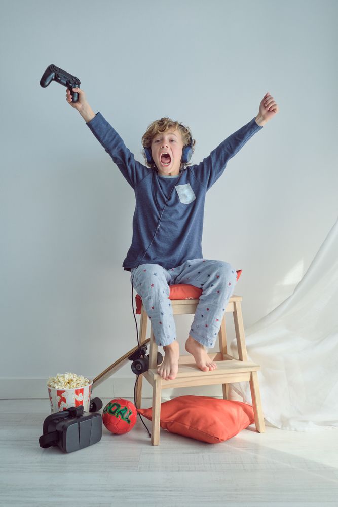 Excited boy playing video game with controller
