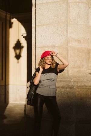 Stylish female standing near building wall