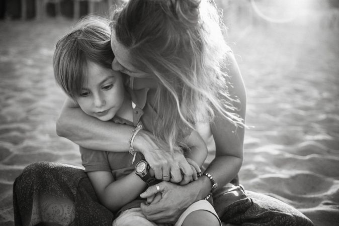 Mother kissing son on beach
