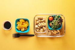 Plastic containers with healthy food and fork