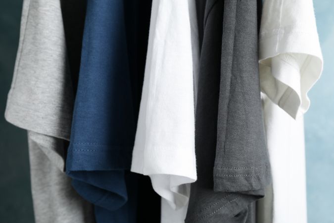 T-shirts on blue background, close up and space for text