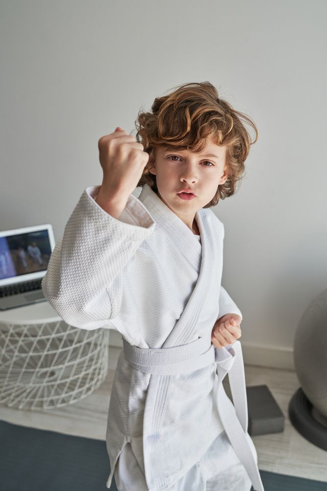 Boy practicing defense blocks at home