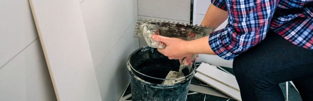 Unrecognizable female bricklayer taking cement from bucket
