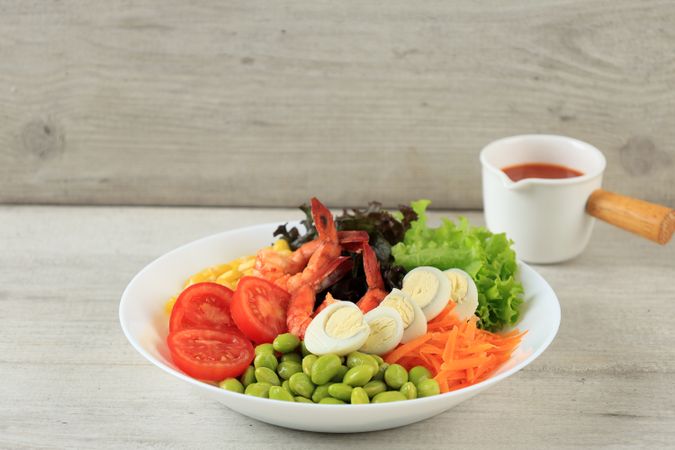 Fresh Shrimp Salad with Quail Eggs, Tomato, Lettuce, Edamame, Corn, and Carrot. With Red Spicy and Sweet Dressing