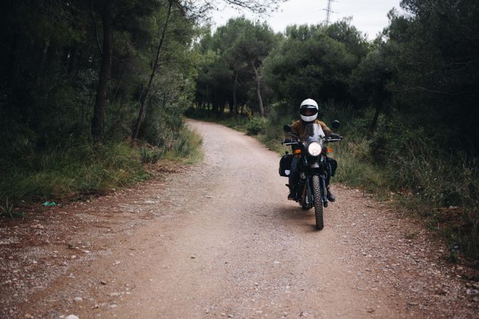 Person on motor bike in forest road