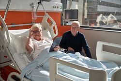 Positive woman smiling near husband during rehabilitation
