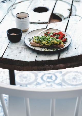 Avocado toast on sourdough bread, cherry tomatoes, coffee, side view with selective focus