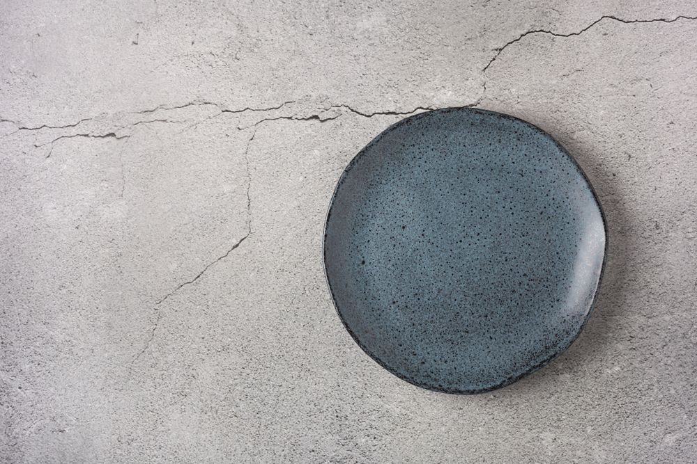 Empty plate on the slate table. Top view of the image.