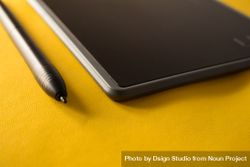 Close up of digital tablet and stylus on yellow table with space for text 49m1A6
