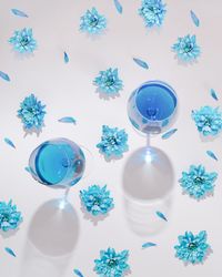 Top view of pattern of flowers and petals with two wine glasses