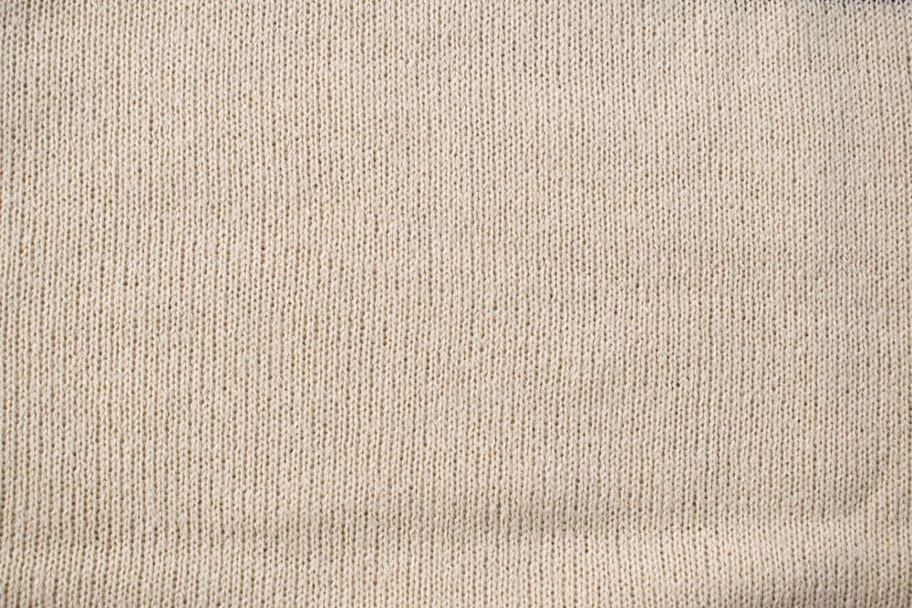 Detailed cream or vanilla knitted fabric background texture.