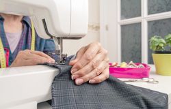 Seamstress hands working on a sewing machine