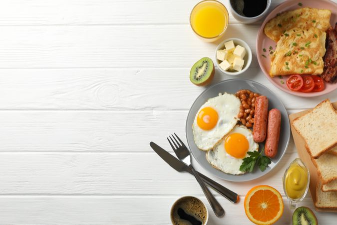 Full breakfast with eggs, beans, sausage, fruit and orange juice, copy space