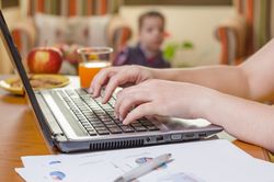 Woman hands writing in notebook and boy playing