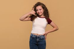Young girl gesturing call me sign