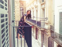 Cheerful woman in dress on balcony