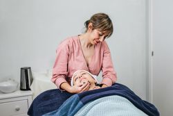 Smiling masseuse doing massage for woman in spa salon