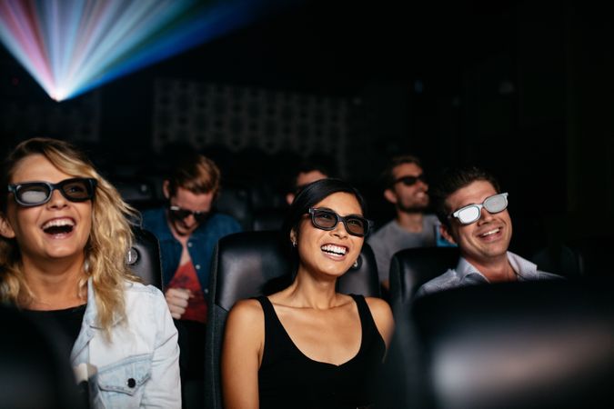 Young men and women wearing 3d glasses in cinema hall