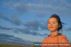 Beautiful little girl looking out to watch the sunset 0KPRV5