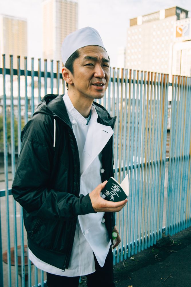 Man in leather jacket holding a small notebook outdoor