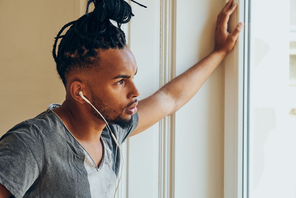 Black man looking out window