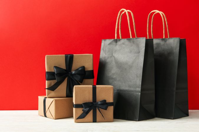 Gift boxes and paper bags against red background