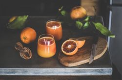 Two glasses of freshly squeezed blood orange juice, with squeezer