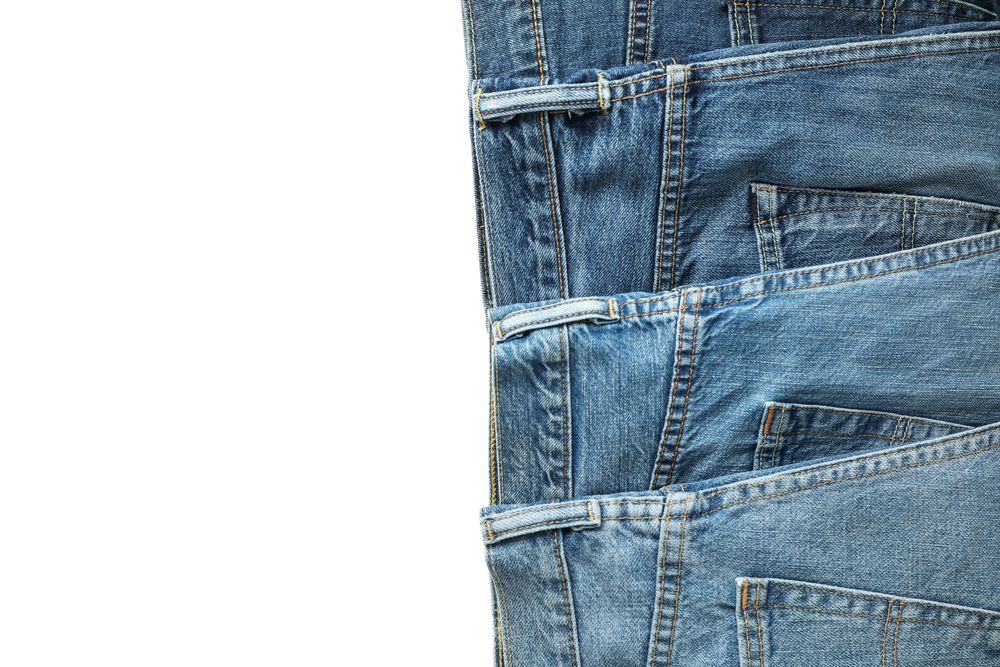 Jeans of different colors isolated on light background, space for text