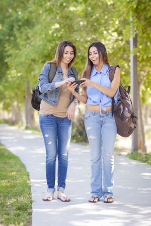 Twin Sisters Looking Over Cell Phone