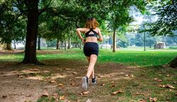 Female athlete running through a park