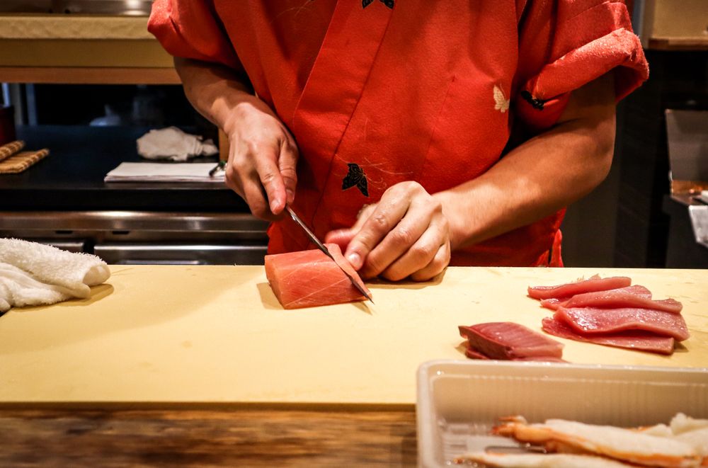 Chef slicing meat on chopping board